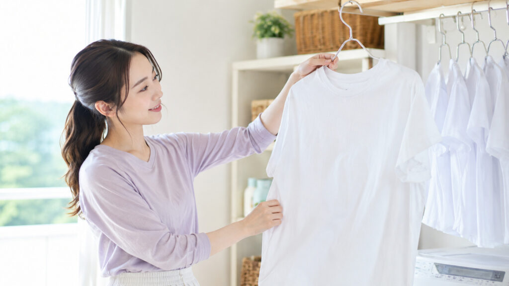 きれいな白Tシャツをハンガーに掛けて整える女性